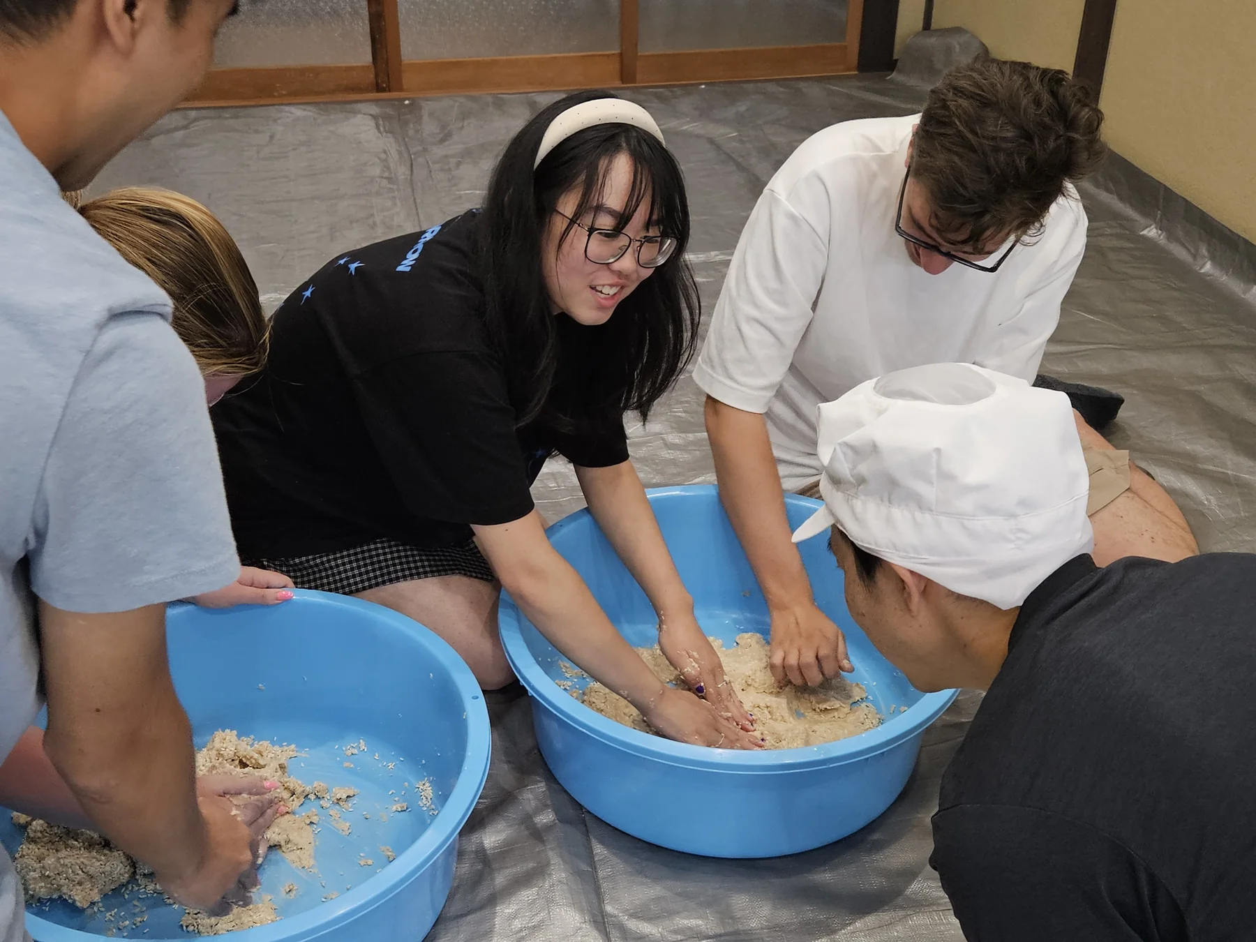 Participants preparing miso together at a workshop in Japan.